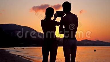 情侣自拍剪影在惊人的日落通过电话。 慢动作。 高清，1920x1080。