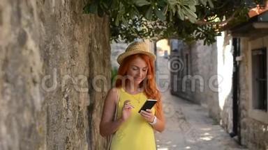 红发女游客在古城街道上使用<strong>智</strong>能手机