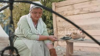 穿中世纪衣服的女人在木桩上煎煎饼