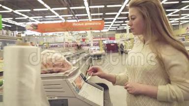 年轻女孩在超市的股票录像中，<strong>体重秤</strong>上的冷冻虾