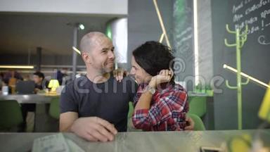 一对年轻快乐的夫妇在一家咖啡馆的桌子上。 他们期待着假期，彼此交流