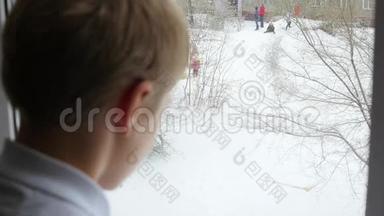 一个少年<strong>望</strong>着<strong>窗外</strong>的雪和玩耍的孩子