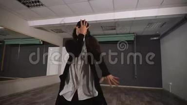 穿着白色衬衫和黑色裤子的女舞蹈演员在教室里用镜子看现代<strong>街舞</strong>
