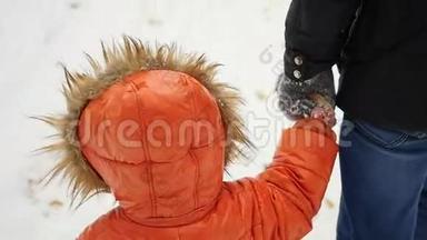 在冬季公园里，一个孩子牵着一个成年人的手走
