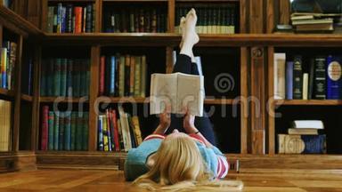 年轻女子躺着看书。 躺在图书馆里
