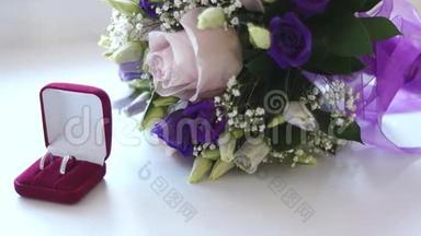 带结婚花束的红盒子里的结婚戒指