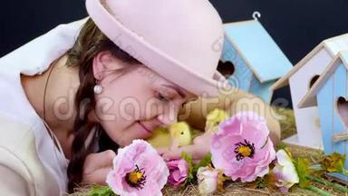 肖像，一个漂亮的年轻女人，有两条辫子，戴着一顶有趣的粉红色帽子，和小黄鸭玩耍。 在里面