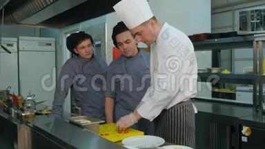 厨师教他的年轻学员如何把沙拉放在盘子里