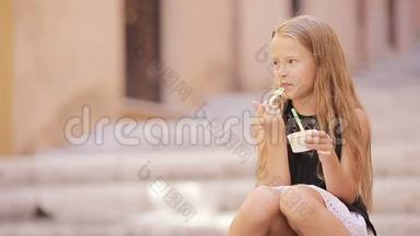 可爱的女孩在欧洲城市户外吃冰淇淋。 可爱的孩子在罗马享受真正的意大利冰淇淋