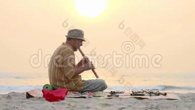 日落时分，老人在海滩上吹<strong>竹笛</strong>