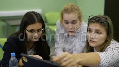年轻的男女<strong>学生</strong>坐在办公桌前，与电脑合作，看监视器，<strong>讨论</strong>和准备