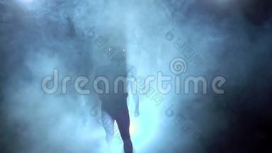 两名足球运动员在烟雾中奔跑，面对战斗。 慢动作