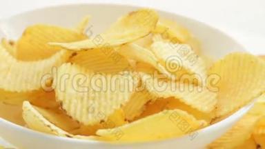 男人的手拿着碗里的薯片，腐烂不健康的有害食物，黄色美味的土豆肋脆薯片