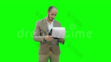集中商人阅读财务报告的绿色屏幕，铬键。