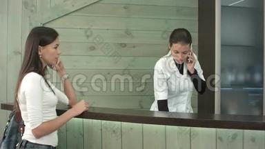 不耐烦的女顾客等待水疗接待员的服务，在电话里交谈