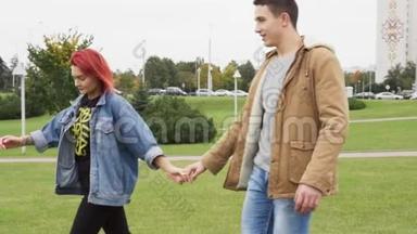 幸福的男人和女人牵着手在城市公园里散步