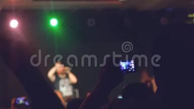 在音乐会晚会上，歌迷们用手机拍摄<strong>视频</strong>和照片，为摇滚音乐活动<strong>欢呼</strong>