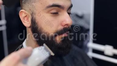 理发师用电动剃须刀刮胡子。