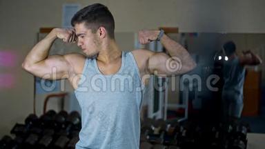 在健身房里，一个男人看着镜子，用肌肉发达的手臂摆动
