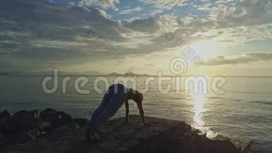 Flycam ViewGirl在海洋日出时在岩石上做瑜伽