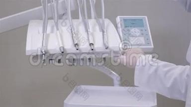 为现代<strong>医院的</strong>牙科医生`手和牙科设备特写，年轻医生检查仪器
