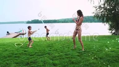 妈妈和儿子在<strong>草坪</strong>上玩耍，倒着水，笑着在<strong>操场</strong>上玩，草地上的背景是