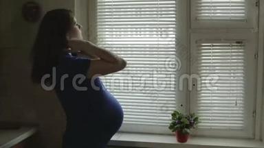 一个肚子大的孕妇正站在窗户边，关上了百叶窗。