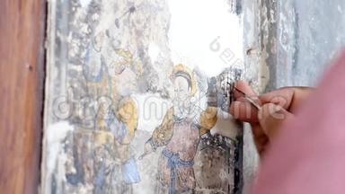 一位绘画艺术家的手在修理一幅中国画。 旧建筑<strong>墙体</strong>国画改造..