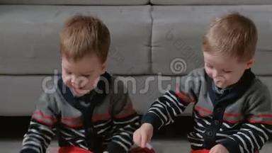 两个<strong>双胞胎兄弟</strong>蹒跚学步的孩子一起画坐在地板上的标记。