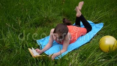 轻松的<strong>小女孩</strong>在田里看书。 可爱的少年躺在<strong>草地上</strong>。 视频镜头高清拍摄静态