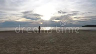 空中：在日落的海滩上混战女跑运动员慢跑. 泰国Koh Phangan。 高清慢速运动。