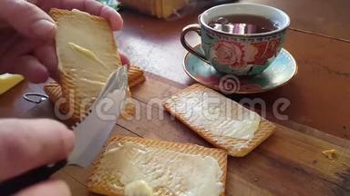 用刀子把黄油撒在麦饼干上吃早餐