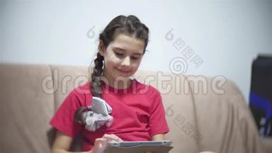 在平板电脑上工作的<strong>女孩</strong>坐在房间里的沙发上。 青少年<strong>社交</strong>媒体<strong>网络</strong>在平板电脑上玩游戏