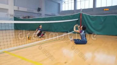 <strong>残疾人运动</strong>。 一位年轻女子坐在体育馆的地板上和教练打排球