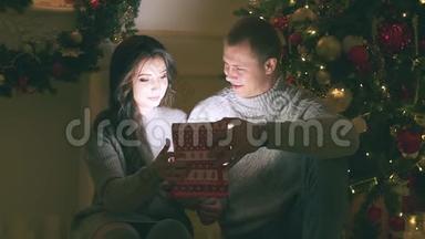年轻夫妇在新年装饰和礼物和<strong>圣诞树</strong>上相爱，<strong>视频</strong>里有噪音