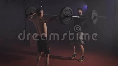 两个强<strong>壮</strong>的<strong>男人</strong>在健身房同时用杠铃做举重。