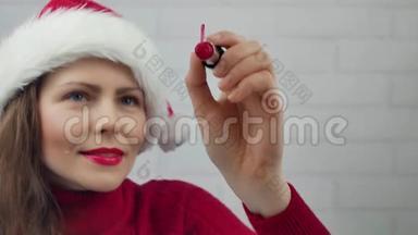 新年快乐。 圣诞女孩在玻璃字上写口红新年快乐。 戴帽子的漂亮女孩发信息。
