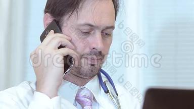 男医生在打电话，医生在他的笔记本电脑办公室工作。