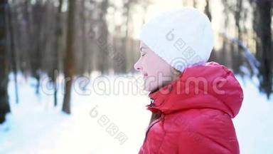 美丽的年轻女子在冬季公园跑步，邀请加入，微笑，玩得开心。 慢动作
