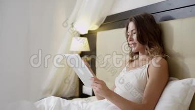 女人在床上用平板电脑