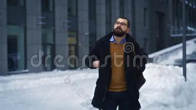 男人在城市里散步，在商业街拍照，在冬天的城市里旅游