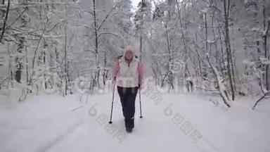 穿着时髦的老年妇女从事一种新型的运动，在冬天的积雪覆盖的木材中行走。 在职养恤金<strong>领取</strong>者