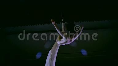 白色空中丝绸上的女舞者，空中扭曲。 慢动作。