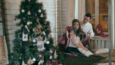 年轻人用温暖的毯子呵护他的女朋友. 一对相爱的情侣庆祝圣诞节。