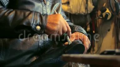 鞋匠<strong>正在修理</strong>一只鞋，用胶水粘在他的旧鞋底上。
