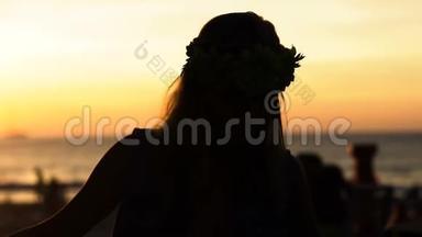 夕阳西下，快乐的女人在海滩上跳舞，背景是大海