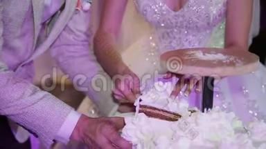 切割白色婚礼蛋糕新娘和新郎。