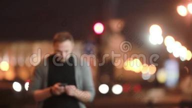 帅哥走在街上，打电话，挂断电话就走了。 城市灯光模糊。 现代技术。