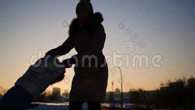 女孩在冬天日落时和婴儿玩。 双<strong>手环</strong>抱