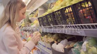 一位女士在一家超市的蔬菜货架上买食品杂货，他正在杂货
